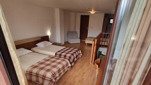 A hotel room with two beds, a sofa, a small table, and a chair. - 1BR Homey Duplex 300mbps Wifi 2 Floor With Washer (Bansko)