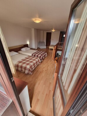 Une chambre d’hôtel avec deux lits, un canapé, une petite table et une chaise.