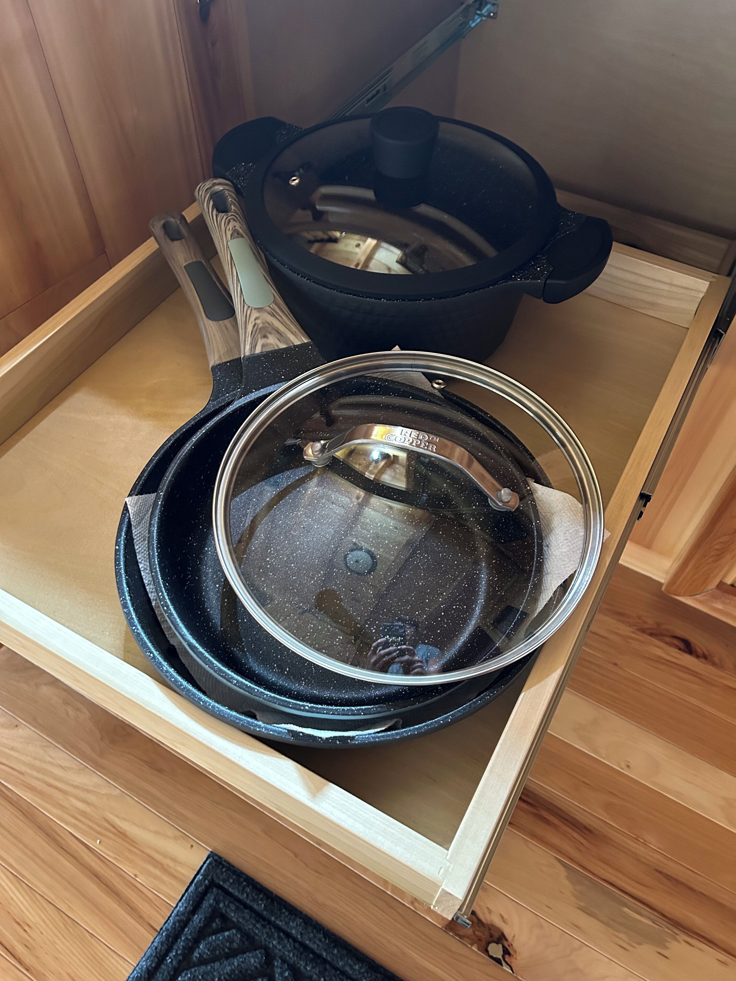 A kitchen with a stove, a pot, and a pan on a wooden countertop.