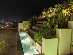 A nighttime outdoor water feature with steps and plants, set against a cityscape. - Hotel Nyzote Inn (Dhaka)