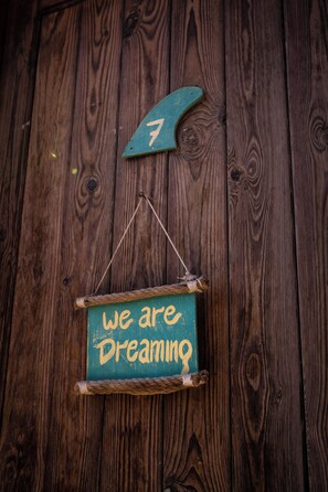 A rustic wooden wall with a hanging sign that reads "we are dreaming." - Eldorado Lodge & Restaurant (Dahab)