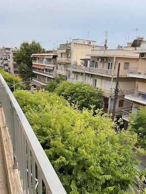 Ett bostadsområde med flerfamiljshus, balkonger och tät vegetation.