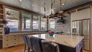 A spacious kitchen with a large island, wooden cabinets, and a stainless steel refrigerator. - 6BD, 5 Bath - Mountaintop Mansion in the Sky (Tellico Plains)