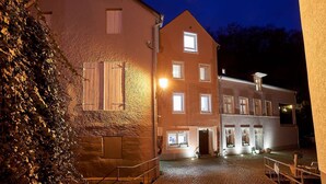 En byggnad med många fönster och en innergård med kullerstenar.