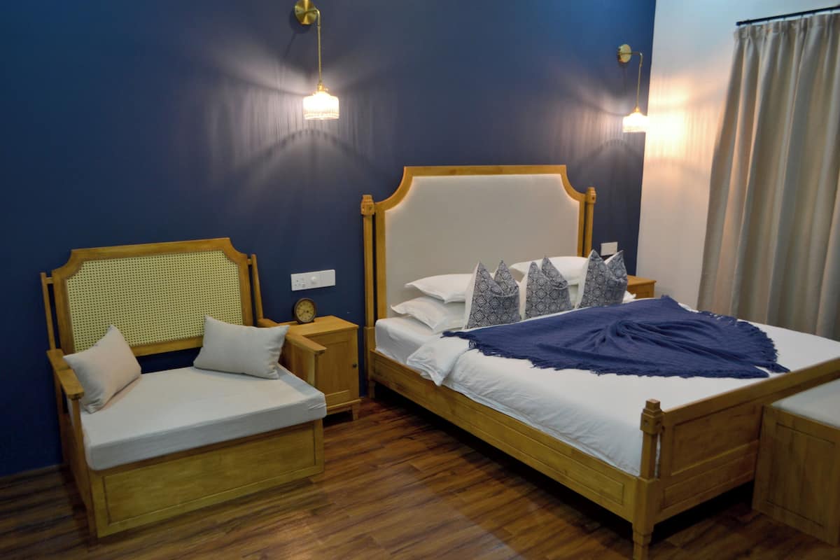 A bedroom with a wooden bed, a wooden bench, and a nightstand with a clock.