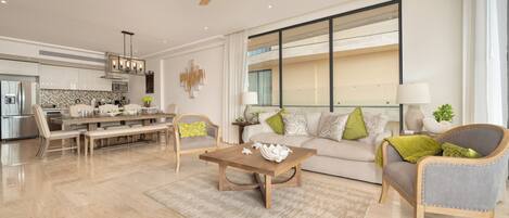 A modern living room with a dining area, a large window, and a ceiling fan.