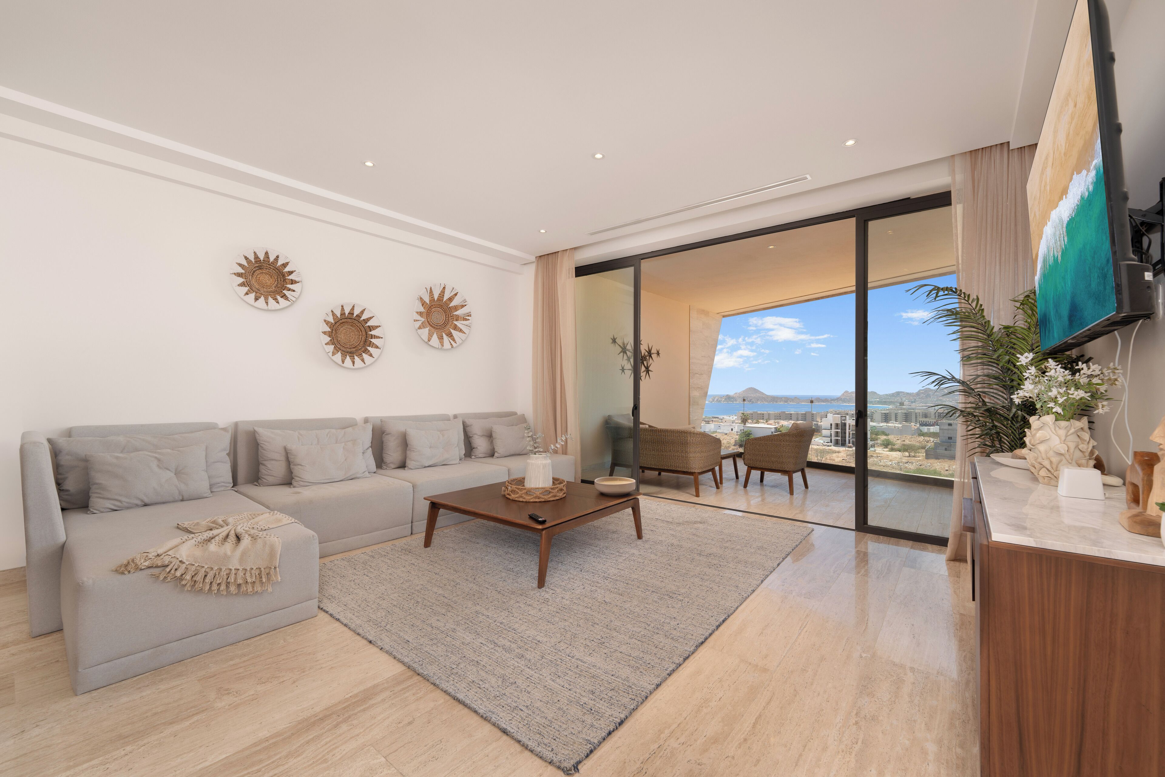 Uma sala de estar moderna com sofá, mesa de centro e vista para a cidade.