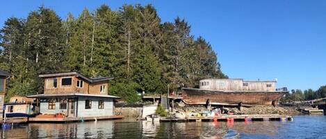 A waterfront property with a houseboat and a traditional house.