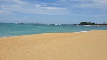 On the beach, white sand, sun loungers, beach umbrellas