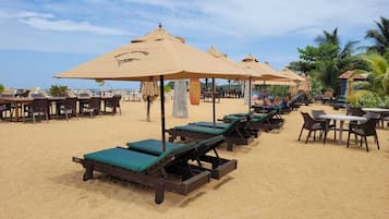On the beach, white sand, sun-loungers, beach umbrellas