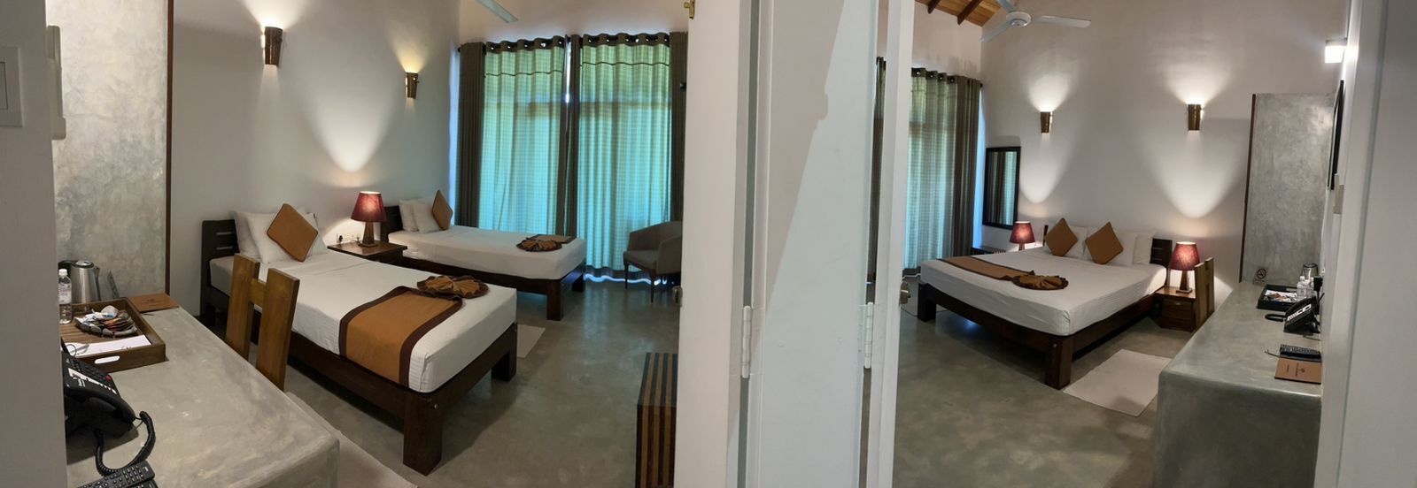 Een hotelkamer met twee bedden, een bureau en een stoel.