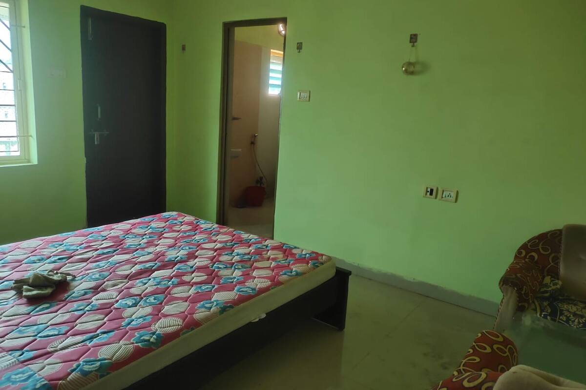 Una habitación con cama, silla, puerta y ventana.
