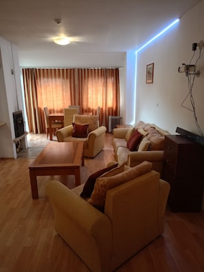 A living room with a sofa, armchairs, a coffee table, and a TV stand. - Mountain Paradise 1 - 1 Bedroom South Facing Balcony - 300mbps Wi-fi (Bansko)