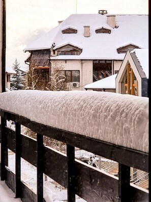 A snow-covered balcony with a wooden railing. - Mountain Paradise 1 - 1 Bedroom South Facing Balcony - 300mbps Wi-fi (Bansko)