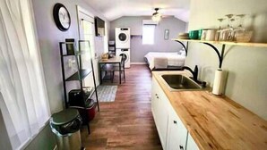 Una cocina compacta con encimera de madera, un lavamanos y una zona de comedor con mesa y sillas.
