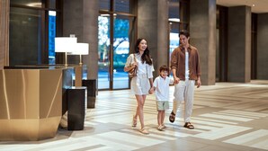A modern hotel lobby with a reception desk, large windows, and a geometric floor pattern. - Courtyard by Marriott Bangkok Suvarnabhumi Airport (Bangkok)