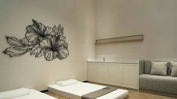Une salle de spa moderne équipée de deux tables de massage, d’un canapé et d’une œuvre d’art accrochée au mur.