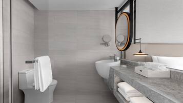 A modern bathroom with a toilet, bidet, and sink.