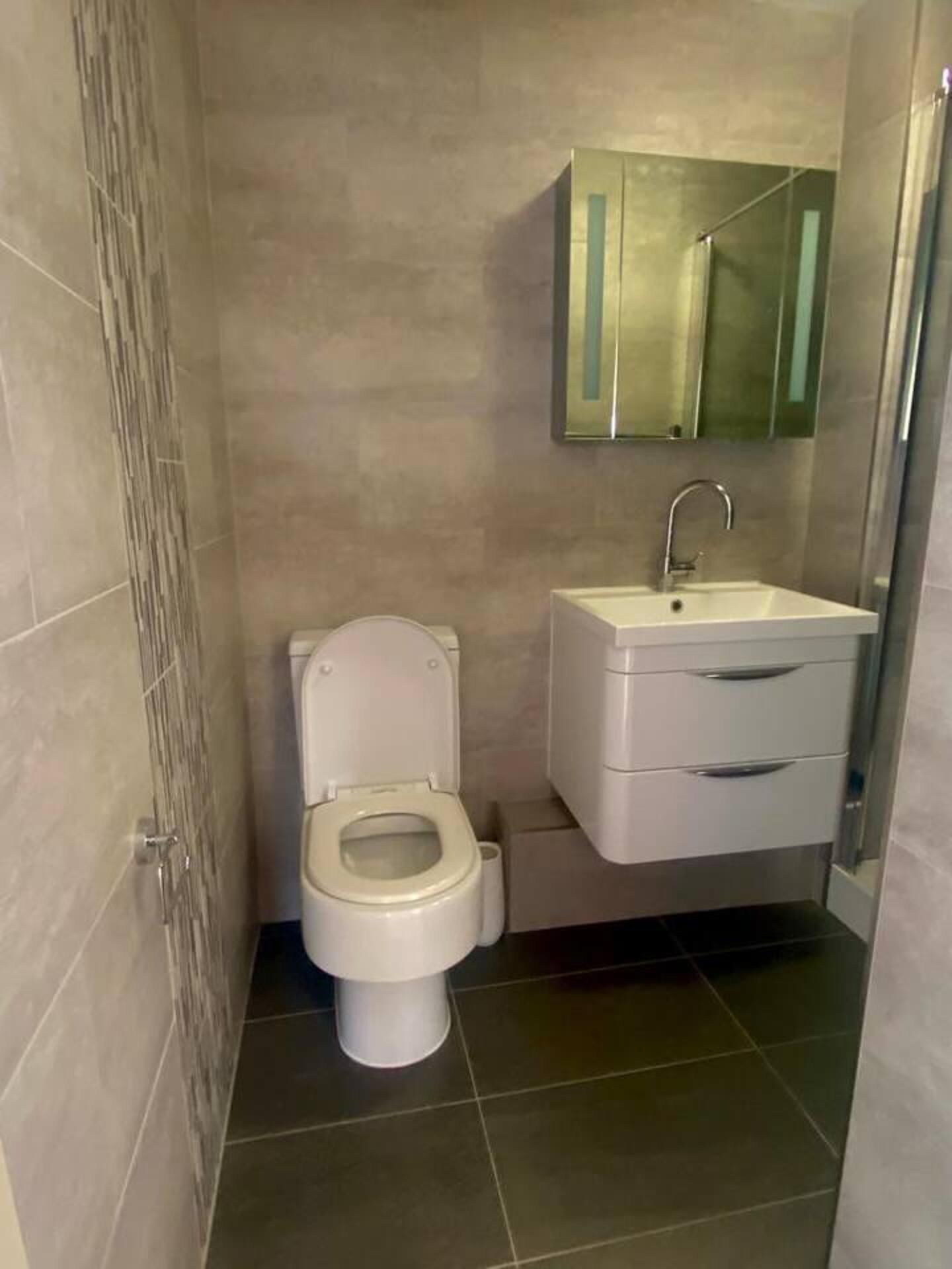 Un baño con inodoro, lavabo y espejo.