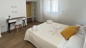 Une chambre d’hôtel avec un lit, un bureau et une armoire.