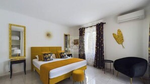 Une chambre d’hôtel équipée d’un lit, d’une chaise, d’un miroir et d’un appareil de climatisation.