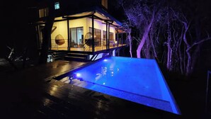 A modern house with a swimming pool at night, illuminated by blue lighting. - Casa Vail, surrounded by jungle in Nosara area (Nosara)