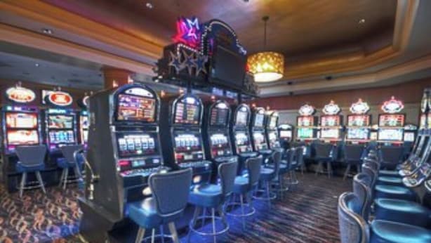 A casino with multiple slot machines, bar stools, and a patterned carpet. - Studio Suite, Ocean View, at Margaritaville Rio Mar Resort, Puerto Rico! (Río Grande)