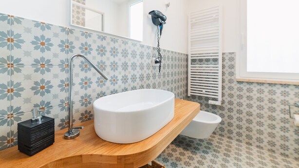 A bathroom with a white sink, wooden countertop, and a mirror. - Castalia Apartments & Rooms (Taormina)