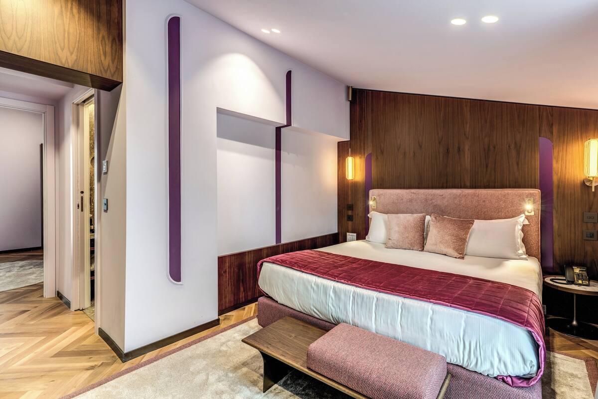 Un dormitorio moderno con una cama grande, una mesita de noche y un armario empotrado.