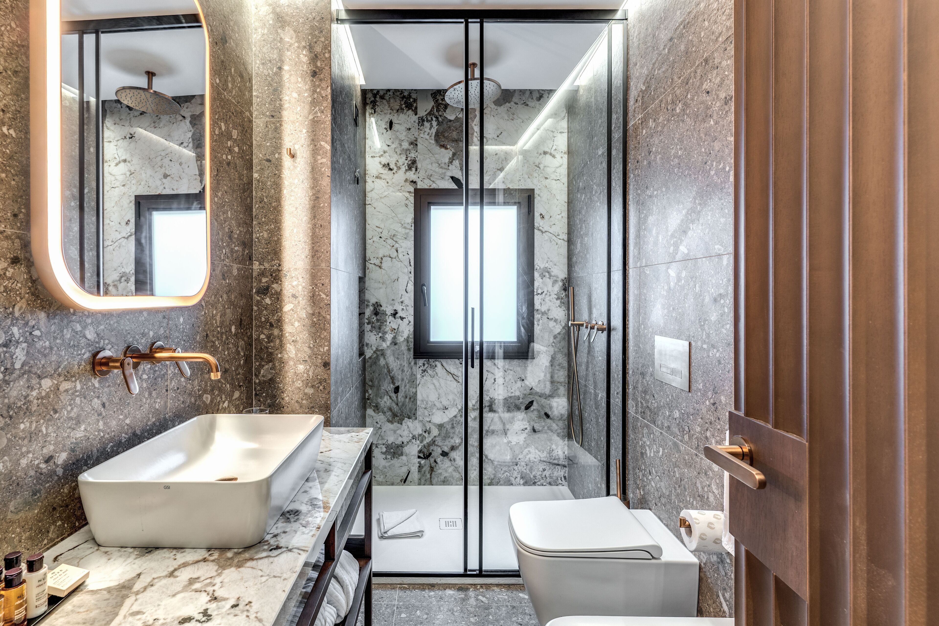 Un baño moderno con una bañera independiente, una ducha con cerramiento de vidrio y un inodoro.