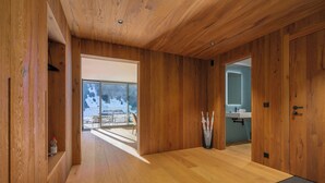 A wooden interior with a view to a balcony and a bathroom.