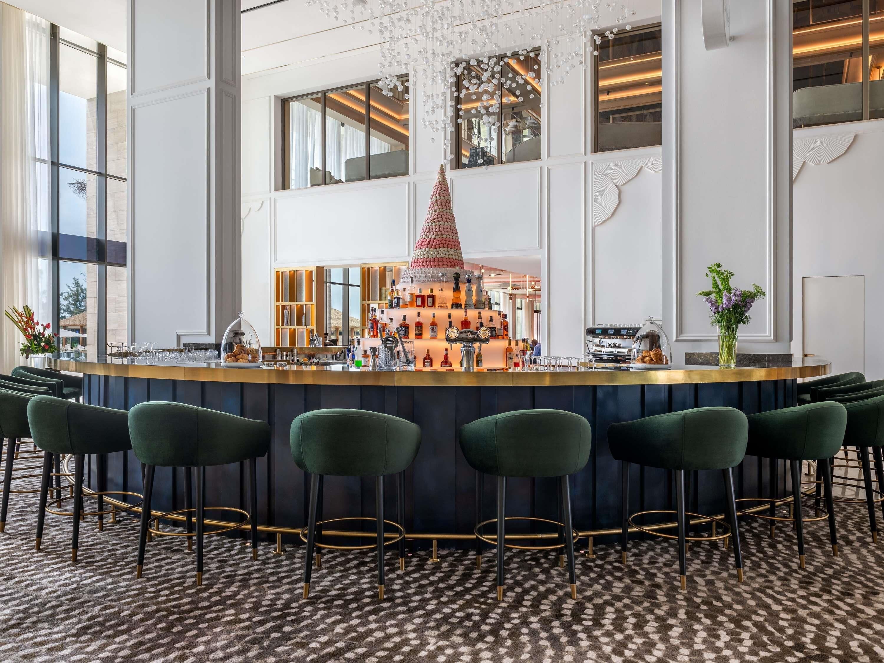 A bar area with a central bar counter, multiple bar stools, and a decorative ice sculpture.
