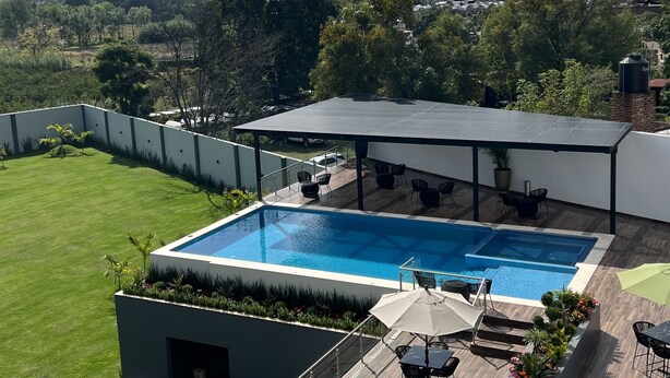 Una piscina en la azotea con vistas al paisaje circundante, incluyendo colinas y árboles.