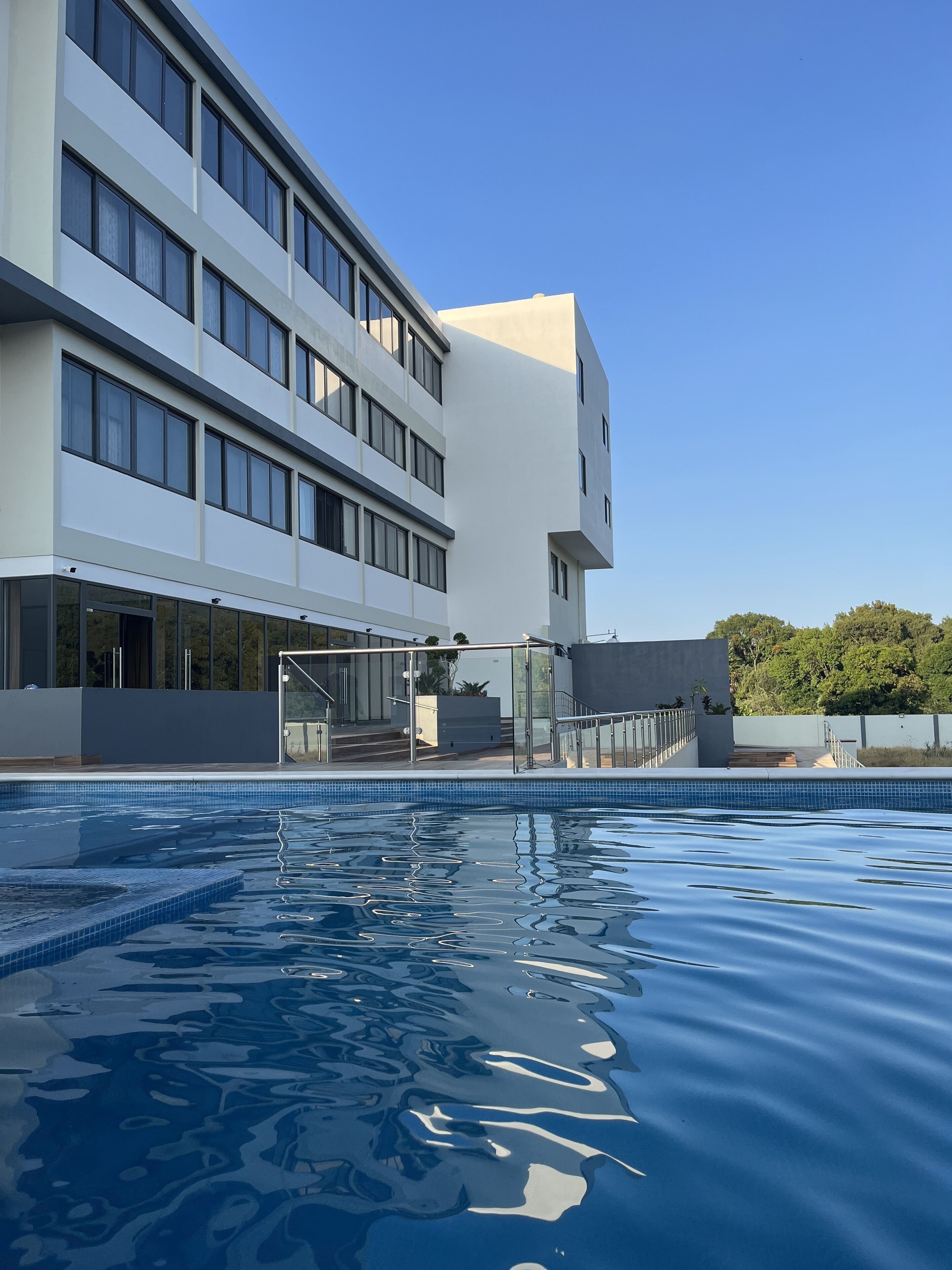 A modern building with a swimming pool in front.