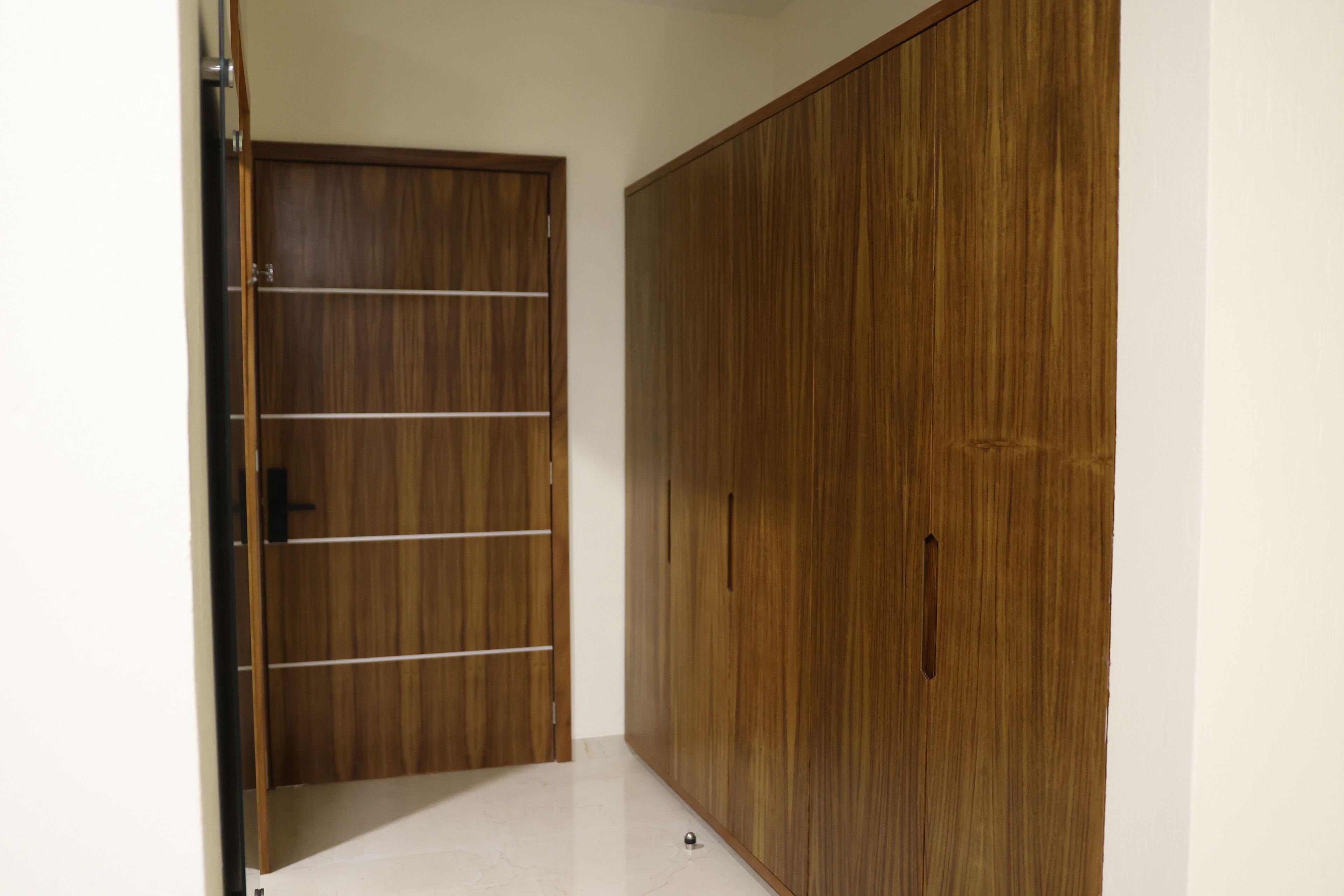 Una habitación con un armario de madera y una puerta.