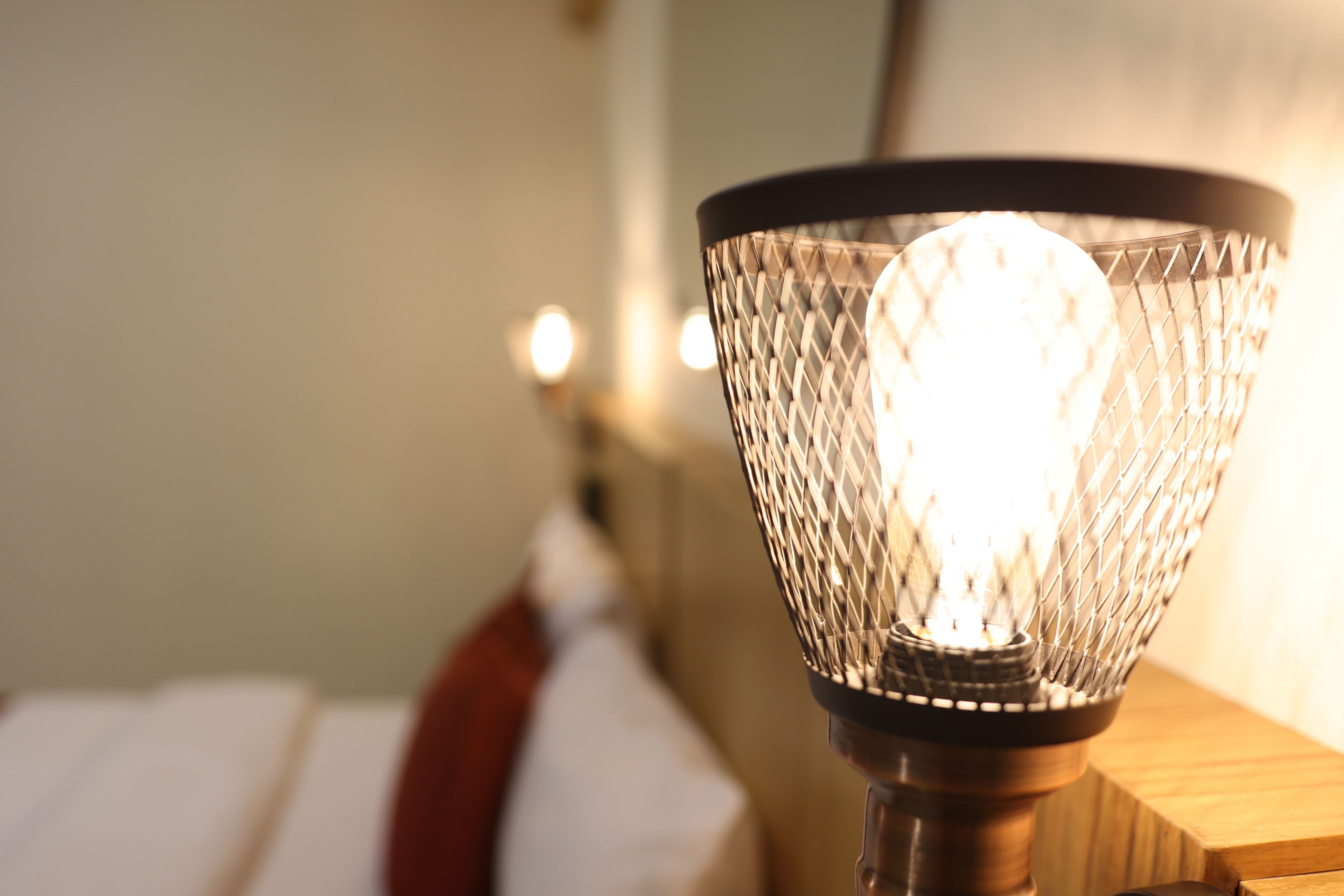 Ein Detailbild einer Lampe mit einer strukturierten Schirm und einer sichtbaren Glühbirne.