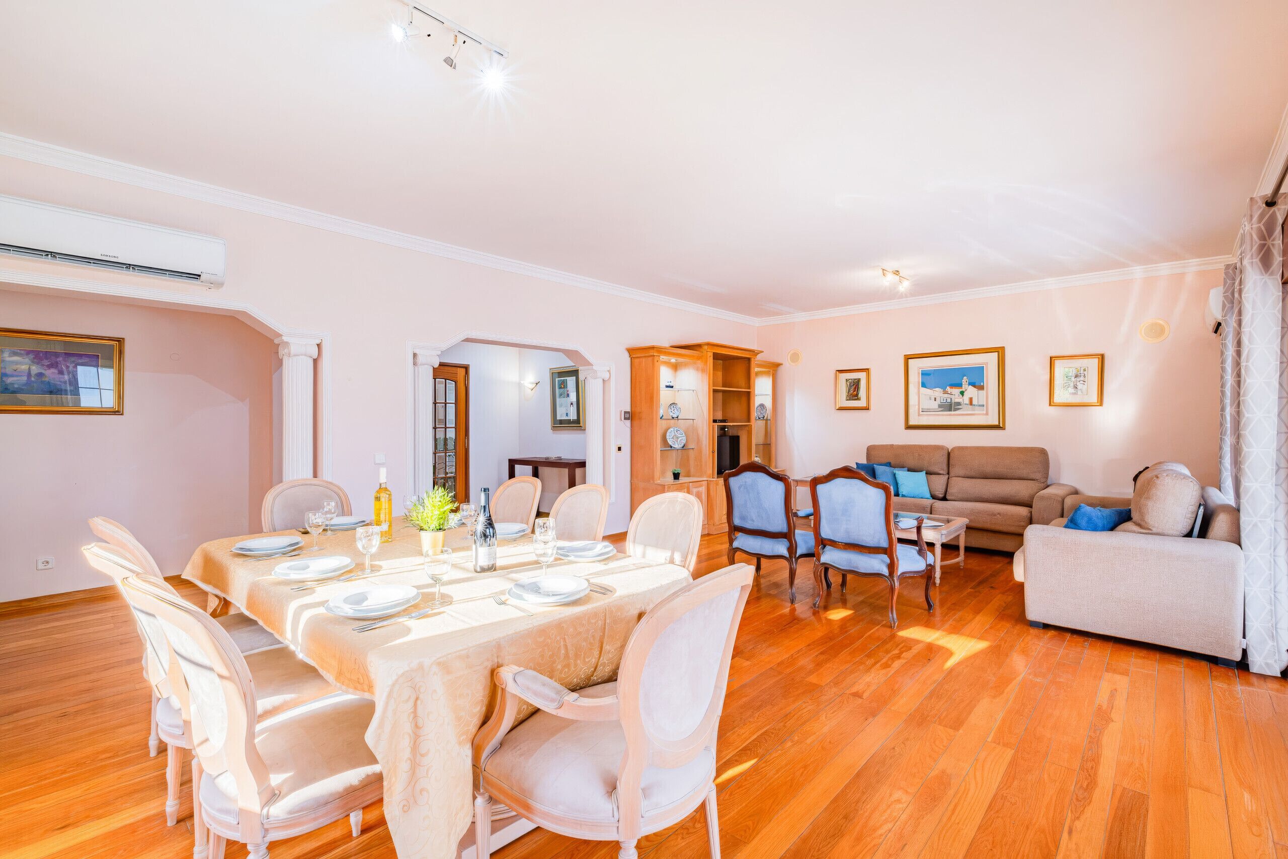 A spacious living area with a dining table set for four, a sofa, and a coffee table.