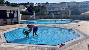 Een zwembadgedeelte met een badmeesterstand, ligbedden en een poolbar.