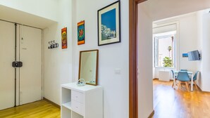 Ein Zimmer mit einem weißen Schminktisch, einem Spiegel und drei gerahmten Kunstwerken an der Wand.