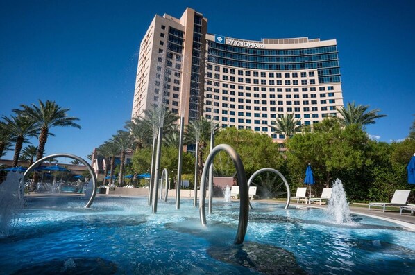 Experience the tranquil atmosphere of this hotel, surrounded by lush palm trees and a serene pool area with fountains.