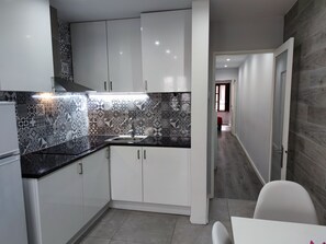 A modern kitchen with white cabinets, a black countertop, and patterned backsplash tiles. - Torre dos Clérigos Apartment
Near all of Porto's major attractions! (Porto)