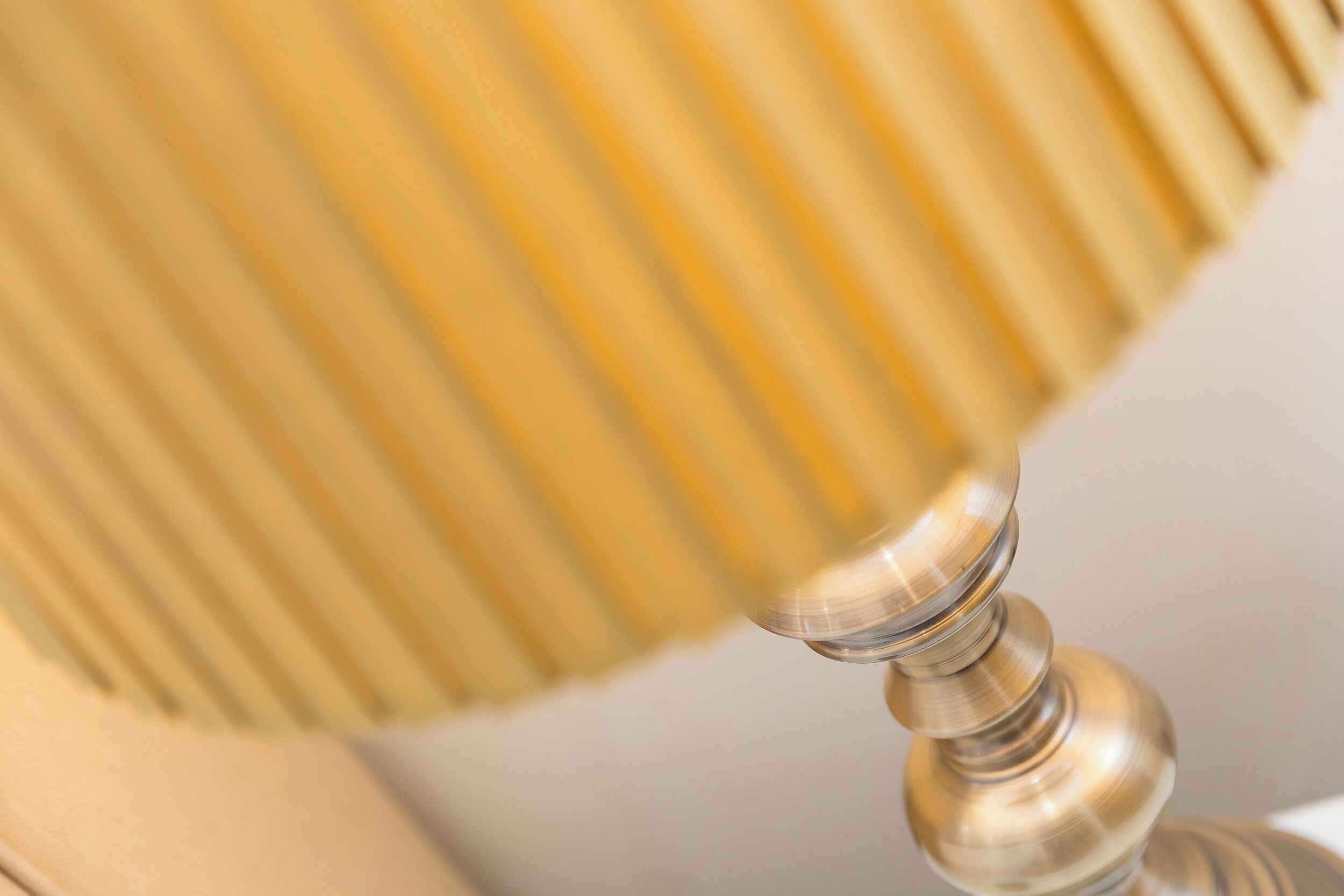Un gros plan d’une lampe métallique dotée d’un abat-jour à nervures.