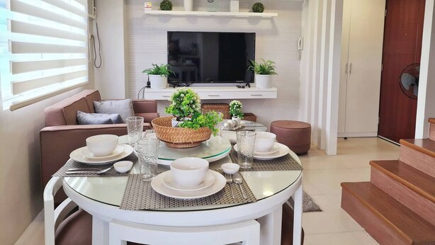 A modern living room with a TV, sofa, and dining table set.