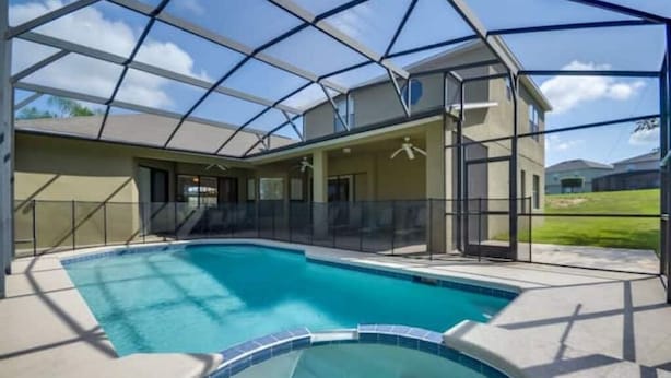 A covered swimming pool with a glass enclosure, adjacent to a building with a patio area. - Mushu's Temple 122LP (Davenport)
