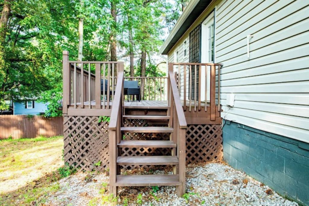 En träveranda med trappsteg som leder upp till ett hus.