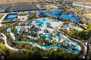 An aerial view of a resort with a large pool area, multiple water slides, and a variety of lounge chairs and umbrellas. - Themed Rooms - Resort Amenities - Fast WiFi - Specials! (Davenport)