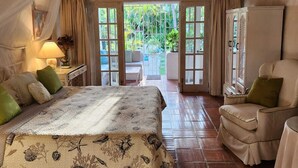 A bedroom with a bed, a chair, a ceiling fan, and a view of the outdoors. - Fabulous, spacious condo with pool, 5 mins from Mullins Beach. (Mullins)