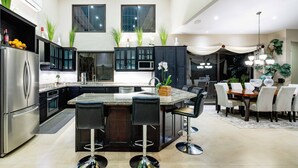 Una cocina moderna con una isla central, electrodomésticos de acero inoxidable y armarios oscuros.