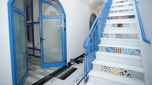 A staircase with blue railings and patterned steps, leading to a room with a blue-framed door. - TNJ TASMANIA HOTEL (Da Nang)