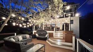 Eine Terrassenausstattung mit einer Couch, einem Glastisch und Lichterketten.